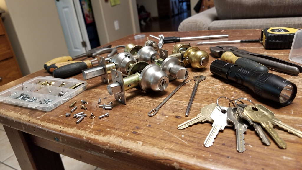 Locksmith tools and a residential door lock on a workbench